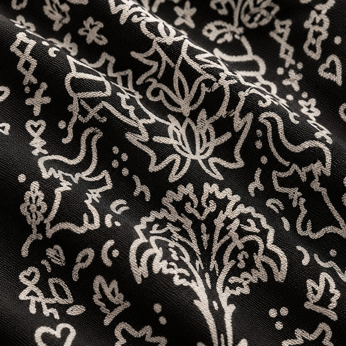 Close-up of the pattern: a hand-drawn flower and tree motif with hearts and stars